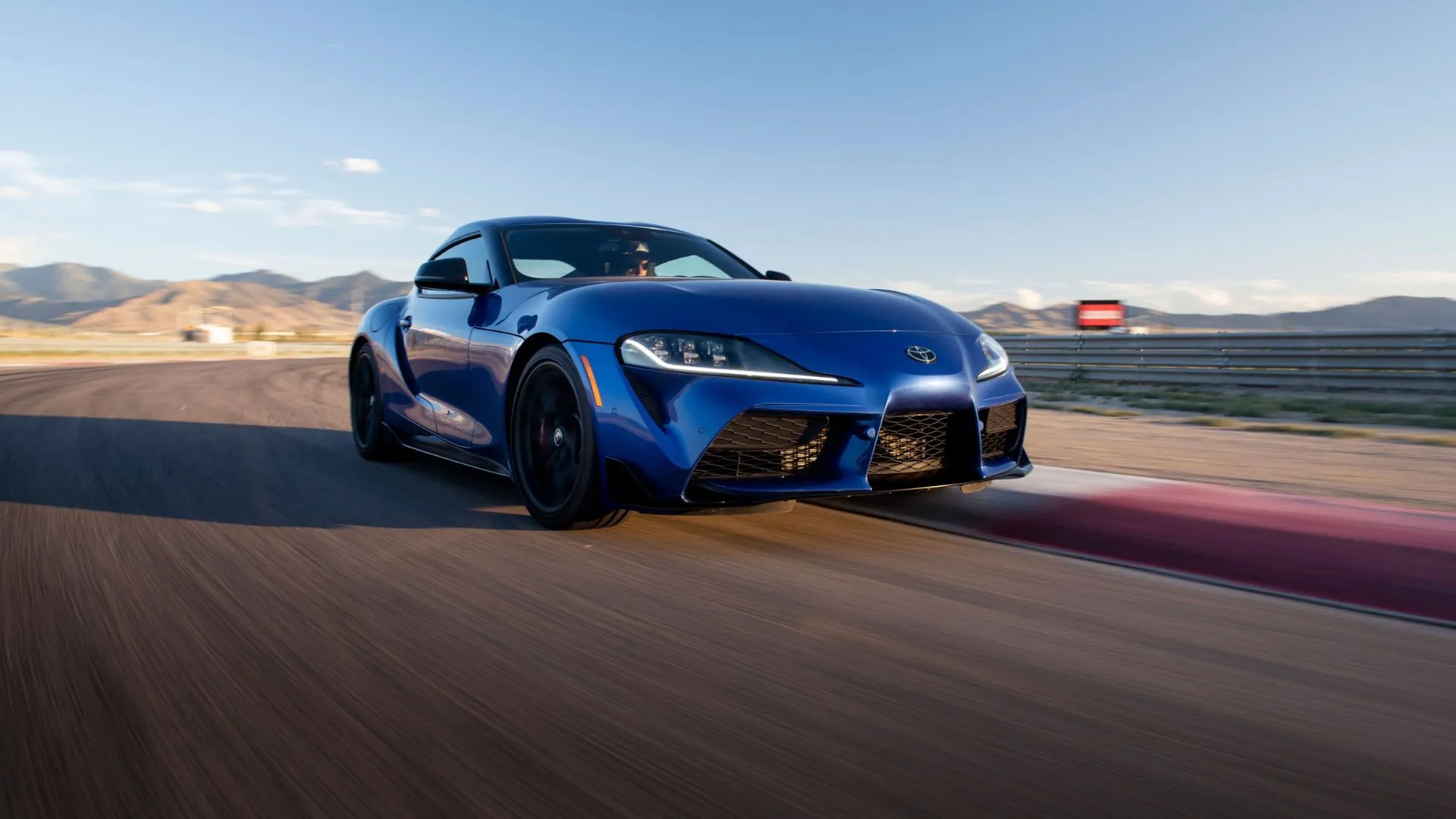 Toyota GR Supra 2026 màu xanh dương đang tăng tốc trên đường đua, thể hiện hiệu suất mạnh mẽ của khối động cơ 6 xi-lanh