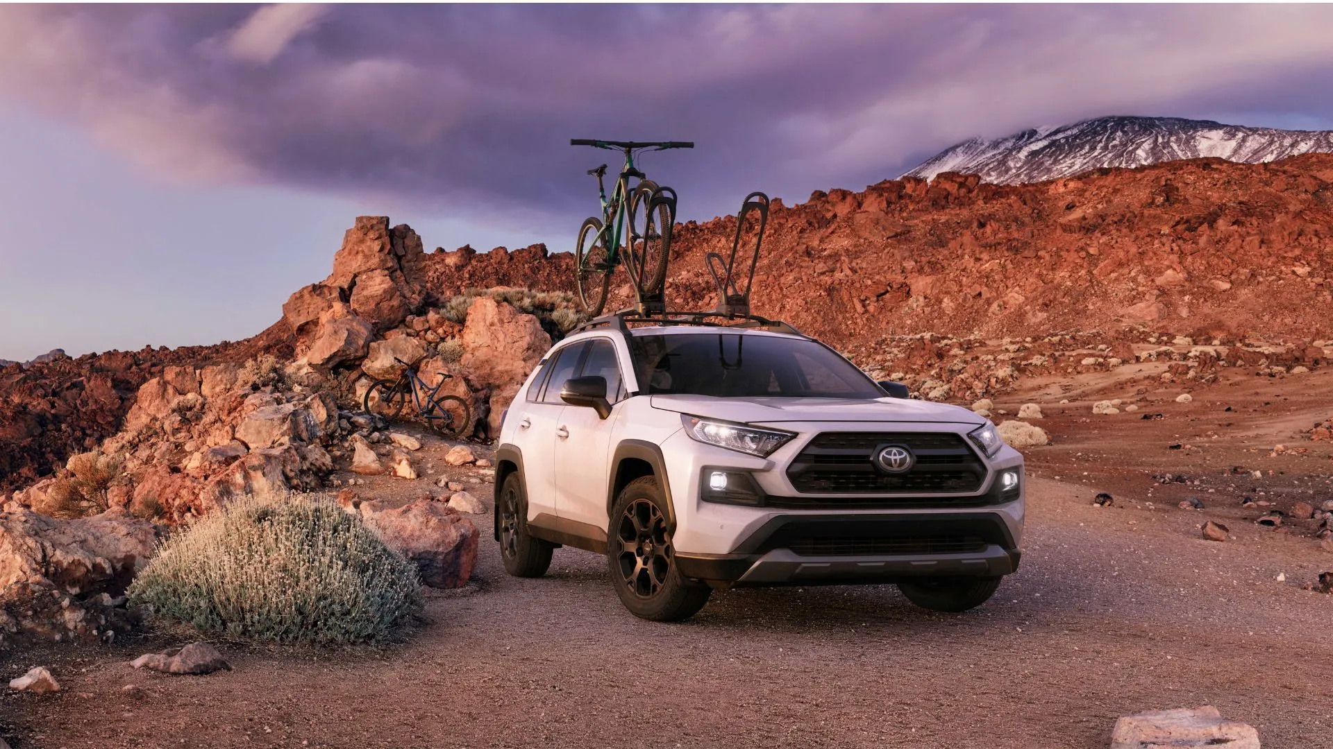 Toyota RAV4 TRD Off-Road 2020 màu trắng chở xe đạp trên nóc, thể hiện khả năng vượt địa hình và tính đa dụng của dòng xe.