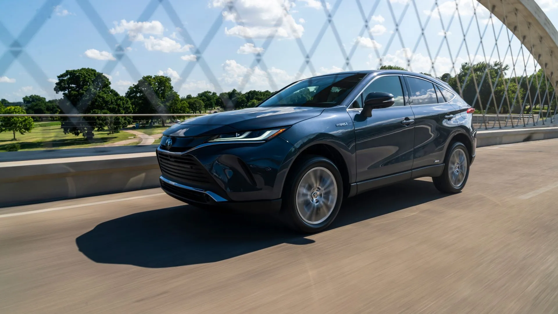 Toyota Venza Hybrid 2021 màu xám bạc sang trọng lướt trên cầu, nổi bật với thiết kế hiện đại và hiệu quả.