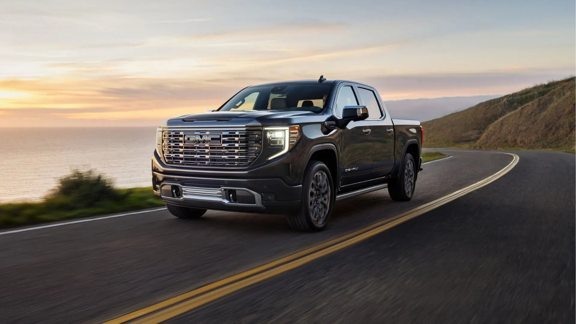 Xe bán tải GMC Sierra Denali Ultimate 2025 màu xanh bạc chạy ven biển
