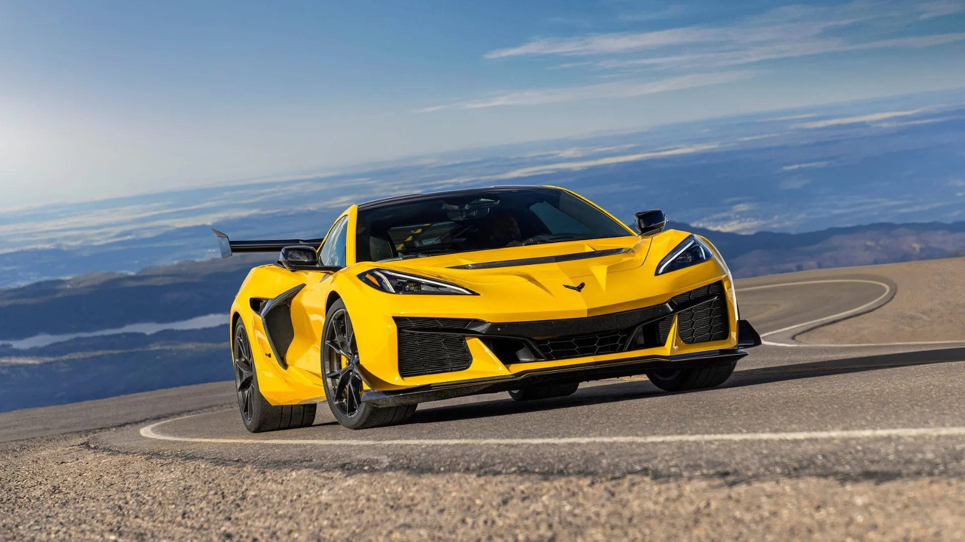 Xe Chevrolet Corvette ZR1 Coupe 2025 màu vàng đang di chuyển trên đường, nổi bật vẻ ngoài mạnh mẽ