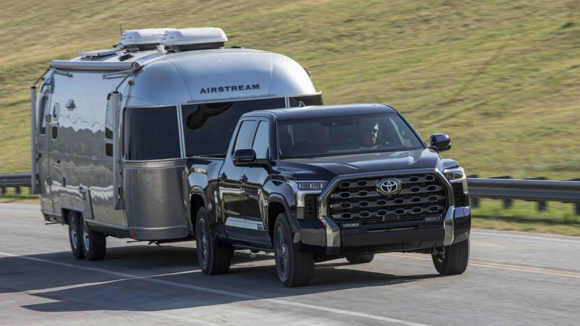 Xe Toyota Tundra Platinum Blueprint 2025 màu xanh kéo rơ-moóc trên đường nông thôn