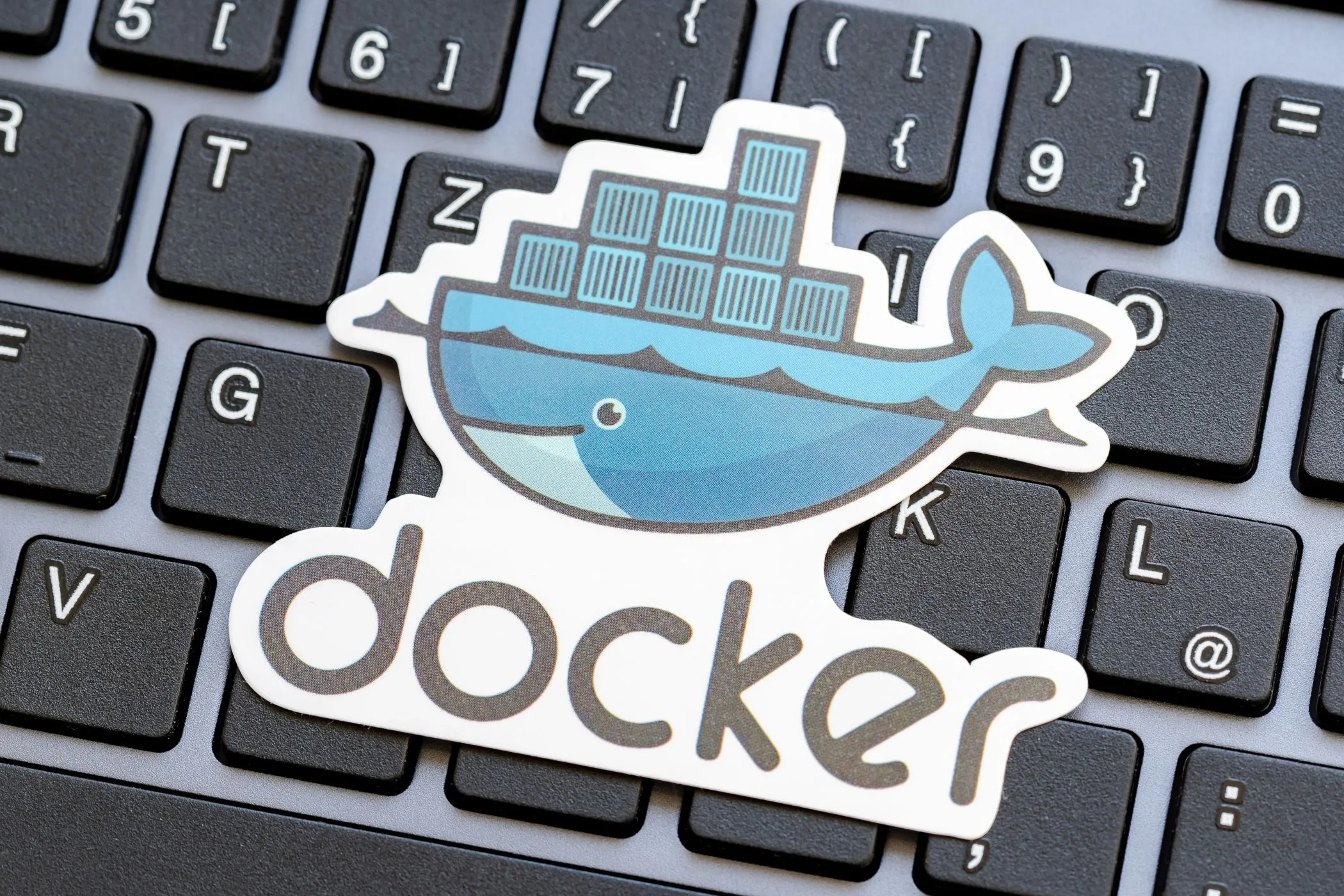 Logo Docker trên nền bàn phím máy tính xách tay, minh họa công nghệ container hóa.