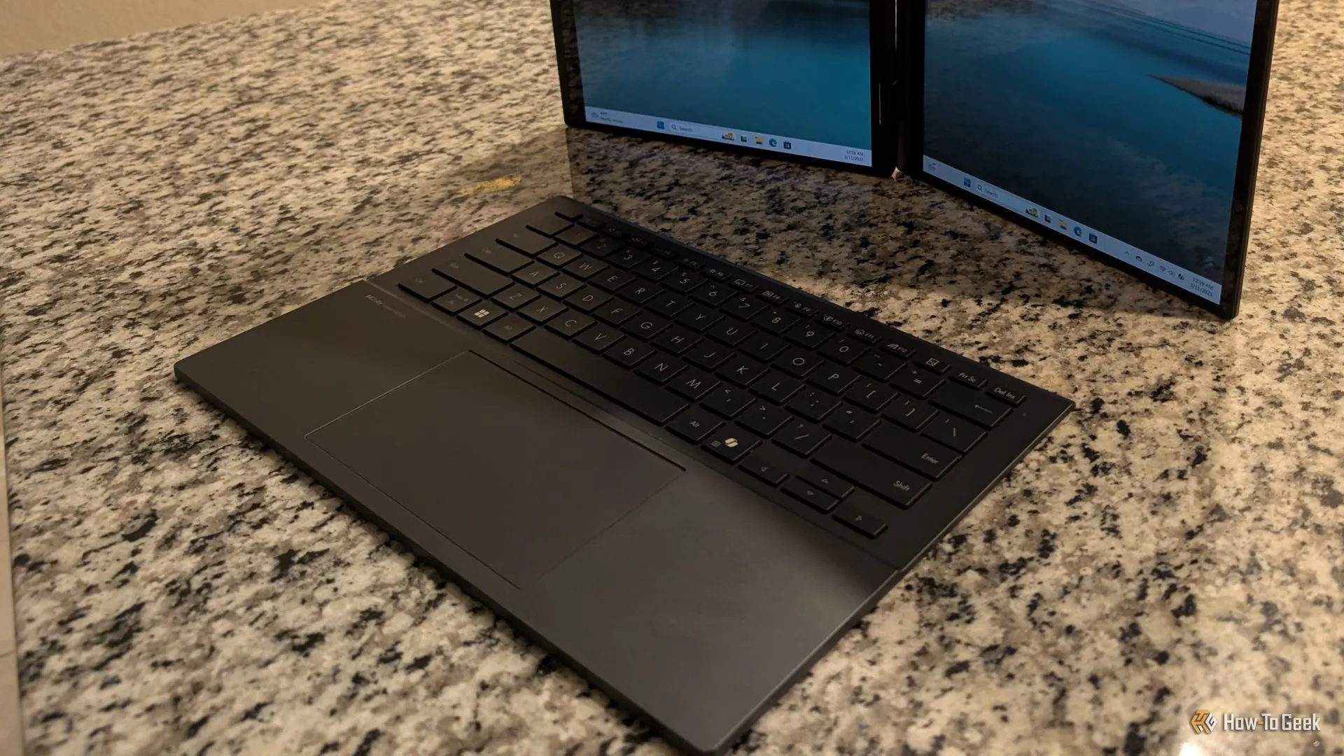 Bàn phím ASUS Zenbook Duo đặt phía trước màn hình đứng theo chiều dọc.