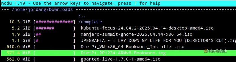 Màn hình terminal Linux với thư mục Downloads đang được duyệt trong ncdu, cho thấy các tệp tin tải về như file ISO chiếm nhiều không gian lưu trữ.