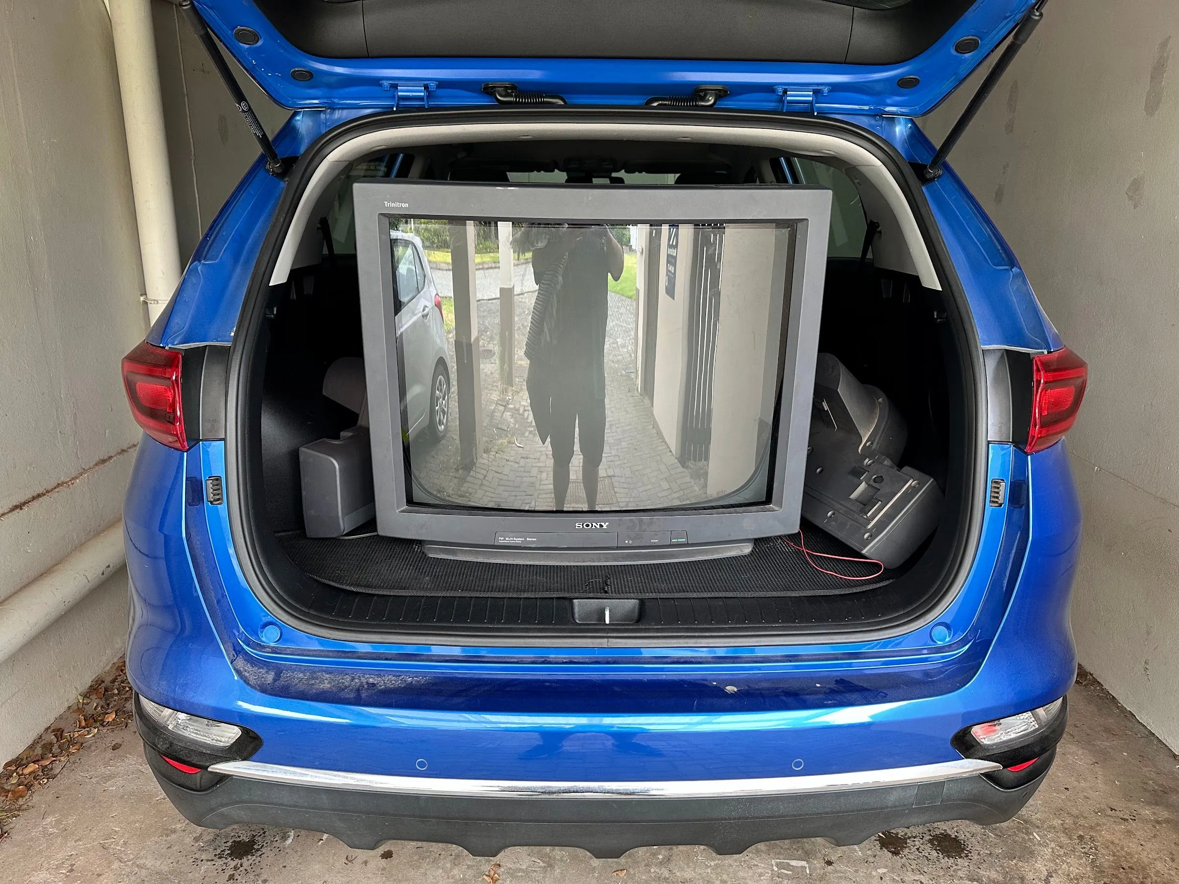 TV CRT Sony kích thước lớn được vận chuyển khó khăn trên xe KIA Sportage, minh họa sự cồng kềnh của TV bóng đèn hình.